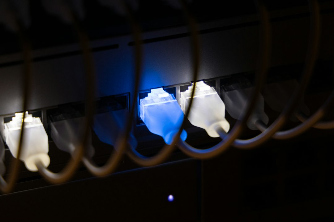 Close-up of a complex and tangled mass of glowing fiber optic cables in a modern server room, representing digital disinfo...