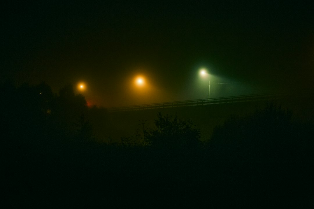 A powerful beam of light from a lighthouse cuts through a dark and foggy night over the ocean, symbolizing clarity and truth in a sea of disinformation.